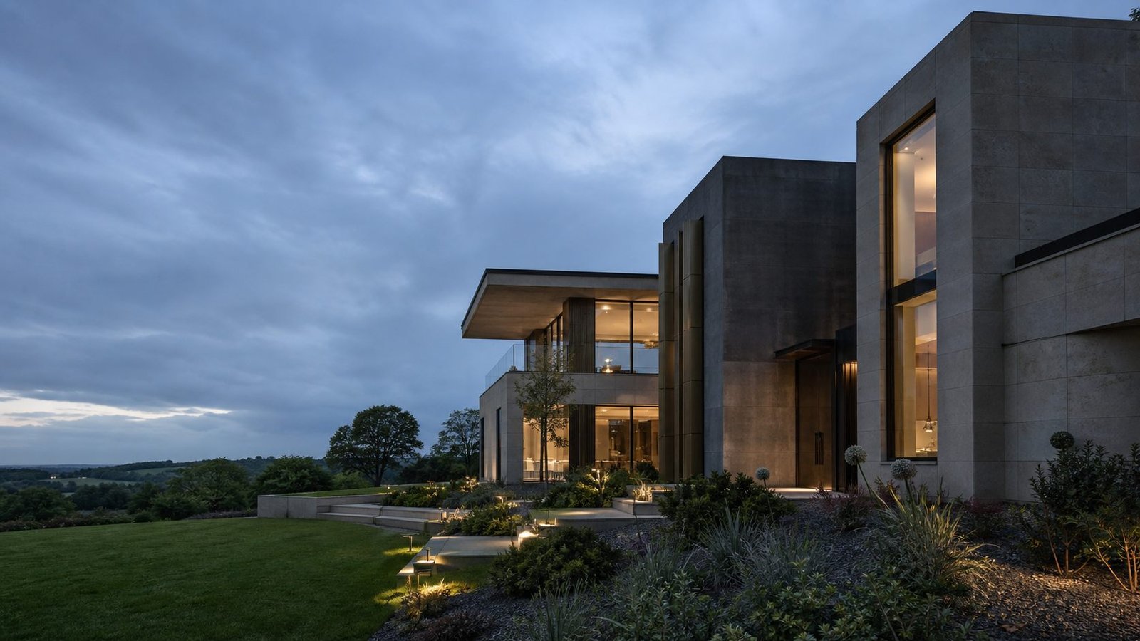 Contemporary stone and glass residence in the English landscape at blue hour